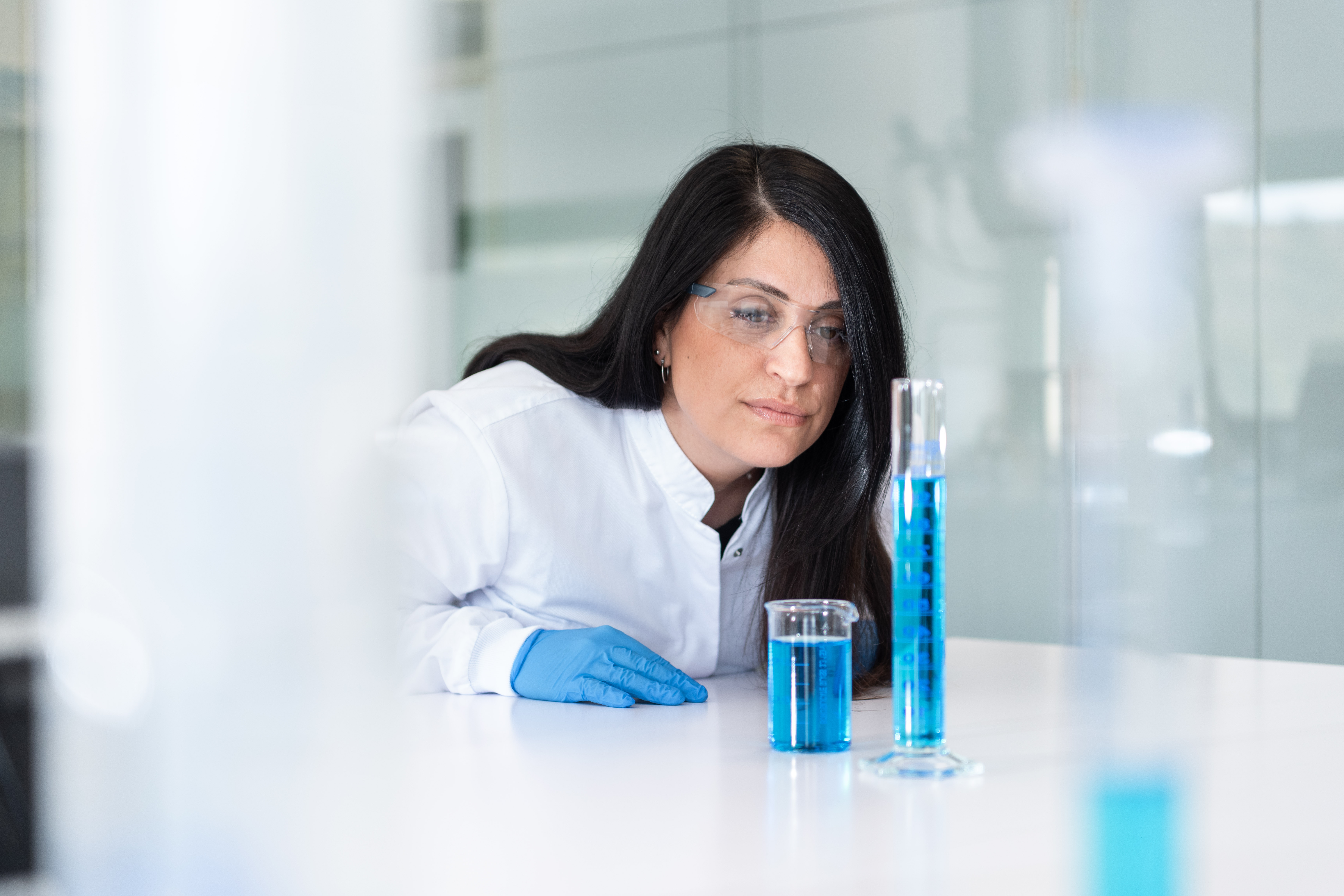 Scientific woman with beaker in lab-img